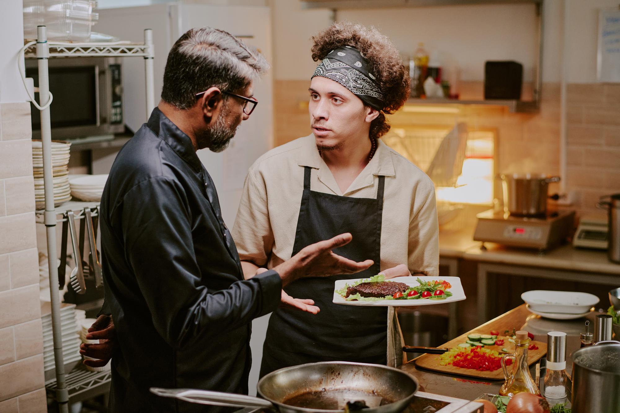 Two chefs discussing recipe notes