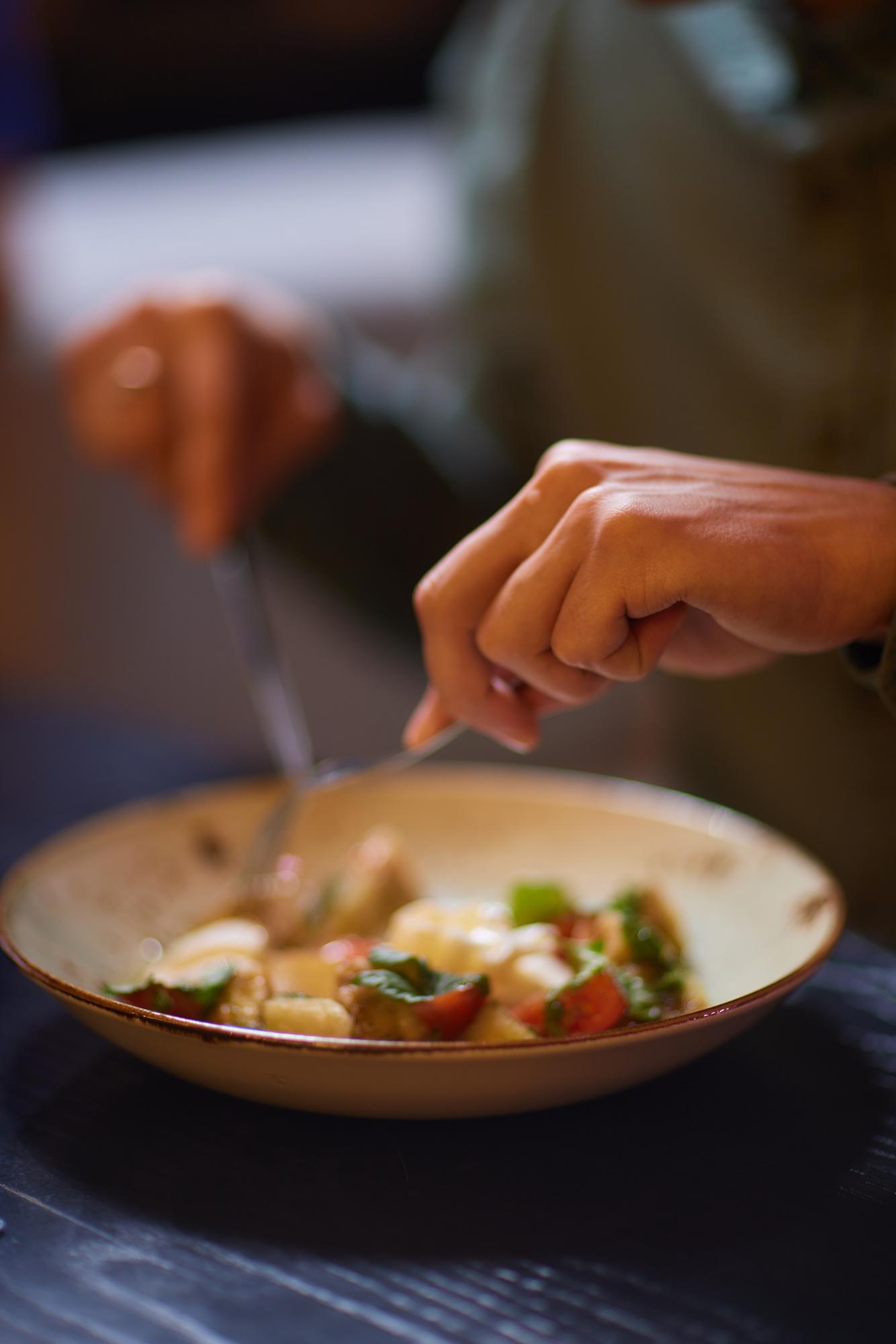 Chef arranging plated dish in warm kitchen